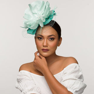 Pale tea green fascinator base with icy blue statement flower